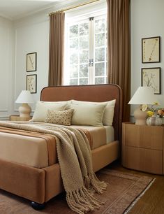 a bedroom with a large bed and two chairs in it's center area, along with a chandelier hanging from the ceiling