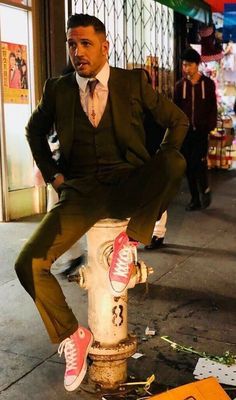 a man sitting on top of a fire hydrant