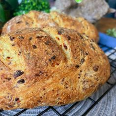 two loaves of bread sitting on top of a cooling rack next to broccoli