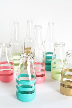 several empty glass bottles with different colored lids