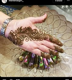 a woman's hand with henna tattoos on it