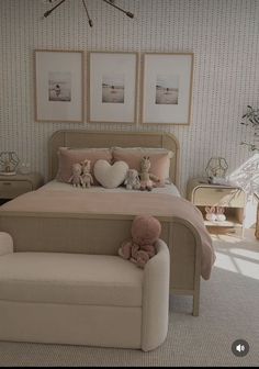 there is a bed with two teddy bears on it and pictures above the headboard