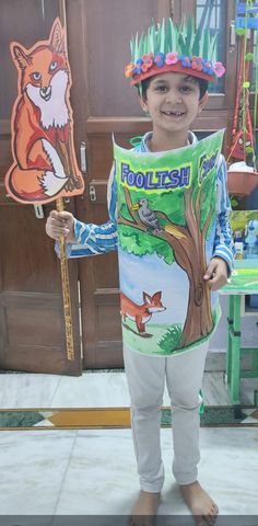 a young boy holding up a sign with animals on it