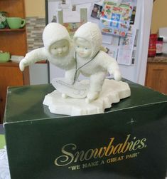 there is a small statue of two snow babies on top of a box that says snowbabies we make a great pair