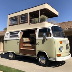 an old vw bus parked in front of a house with its doors open and the windows closed