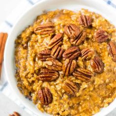 a bowl filled with oatmeal and pecans on top of a table