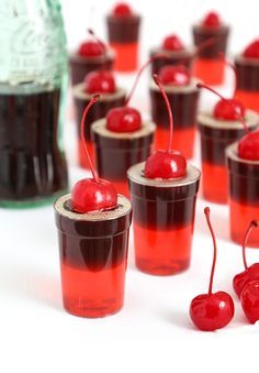 small cups filled with cherries next to a bottle