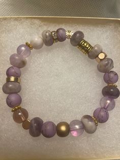 "Gorgeous stretch bead bracelet -Gold detailing, glass and stone beads in shades of purple -Neutral plums, lavender, creams and tan -Matte and shiny gold details -Stretch bracelet so easy to slip on and go! 6.75-7.0\" stretch fit.  -Fits most wrists. -One of a kind! Perfect to stack! See my other listings of bracelets and create a custom stack of your own!  https://www.etsy.com/shop/LivWithGraceStyles" Gold Trendy Stretch Bracelet With Spacer Beads, Trendy Gold Stretch Bracelet With Spacer Beads, Trendy Gold Stretch Bracelet With Faceted Beads, Spiritual Stretch Bracelet With 8mm Beads, Hand-strung Healing Stretch Bracelet, Healing Hand-strung Stretch Bracelet, Gold Stackable Beaded Bracelets For Healing, Gold Stretch Bracelet With Faceted Beads, Gold Hand-strung Czech Glass Bracelets