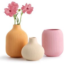 three vases with pink flowers in them on a white background and one is empty