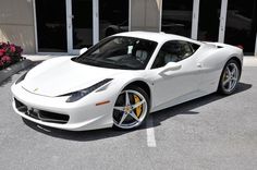 a white sports car parked in front of a building