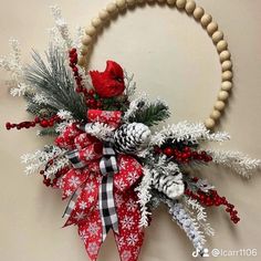 a christmas wreath with pine cones, berries and snowflakes hanging on the wall