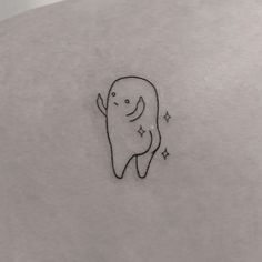 a small tooth tattoo on the back of a woman's shoulder