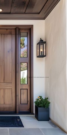 the front door to a house with two planters on either side and one light on