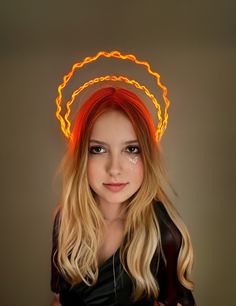 a woman with long blonde hair wearing a neon headband and looking at the camera