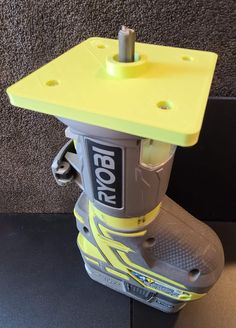 a yellow and gray box sitting on top of a black table next to a wall