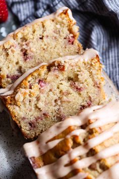 two slices of strawberry bread with icing on a plate next to some strawberries