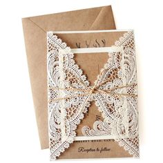 a wedding card with lace on it and a bow tied to the front, in brown paper