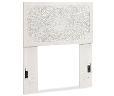 a white fireplace surround with intricate carvings on the front and back sides, made out of wood