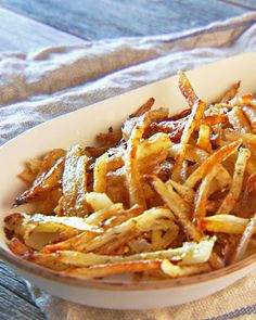 a white bowl filled with french fries on top of a table