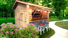 an outdoor bar with three stools next to it and flowers in the foreground