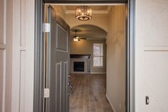 an open door leading to a kitchen and living room with tile flooring on both sides