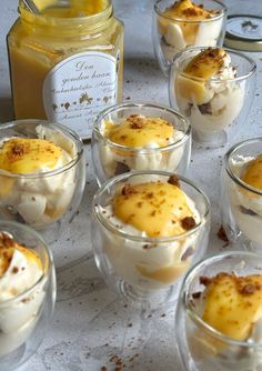 desserts are arranged in small glasses on a table