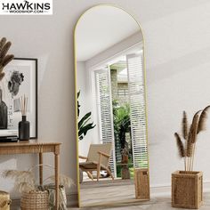 a large mirror sitting on top of a wooden table next to a potted plant