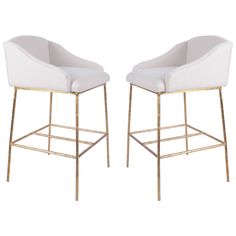 a pair of white and gold bar stools