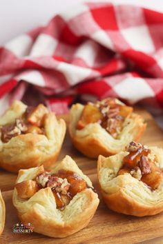 several small pastries on a wooden tray with a red and white checkered napkin