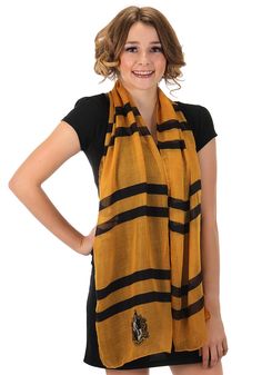 a woman wearing a black and yellow scarf with stripes on the bottom, standing in front of a white background