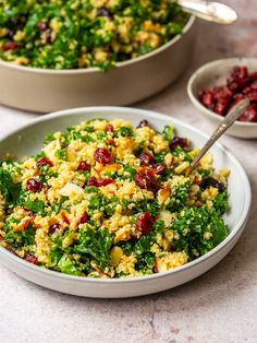 a white bowl filled with food next to two bowls full of cranberries and spinach