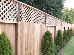 a wooden fence is lined with trees and bushes