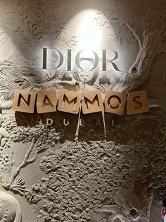 a sign that reads dior nammos duai on the side of a wall