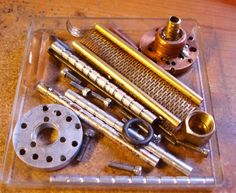 an assortment of metal parts sitting on top of a wooden table