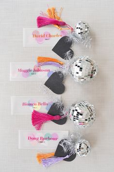 three disco ball place cards with tassels on them