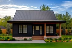 a small black house in the middle of a green yard