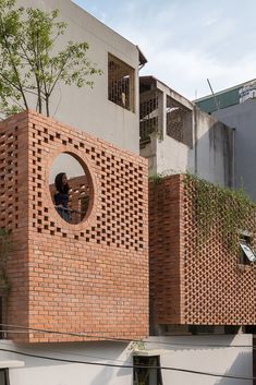 a person standing in the window of a building made out of bricks and brick blocks