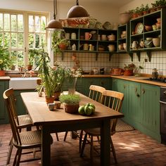 a kitchen filled with lots of green cupboards and wooden table surrounded by potted plants