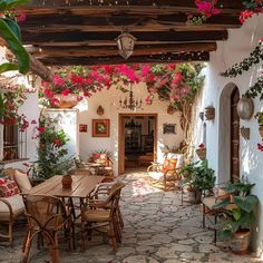 an outdoor dining area with potted plants and flowers on the ceiling, along with wooden tables and chairs