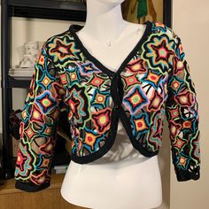 Crocheted Cropped Multicolored Floral Granny Squares Bolero Jacket. Wowow!! Not Quite Granny Squares, But Multi Sized Crocheted Flowers Hooked Together To Create This Lacey Confection! Rainbow Colors On A Black Matrix.Deep V Neckline With 2 Faceted Black Resin Buttons. Cropped Silhouette Has Cutaway From Hem. Shows Off Just The Right Amount Of Skin, While Still Covering You Up! No Size Tag, So You Must See Measurements For Your Best Fit. Photos Show Measurements And Condition. No Smoke,Odors Or Fitted Multicolor Summer Outerwear, Spring Party Outerwear With Patchwork, Multicolor Patchwork Cardigan For Spring, Spring Multicolor Patchwork Cardigan, Fitted Multicolor Spring Cardigan, Fitted Multicolor Bohemian Outerwear, Fit Photos, Resin Buttons, Crocheted Flowers