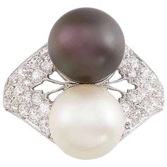 2 pearls ap. 8.8 & 9.0 mm., 42 round diamonds ap. .85 ct., ap. 3.8 dwts. Size 6. Pearl: slightly creamy, cleanish, bubble on inner side, medium luster. Black pearl: brownish gray with visible rose orient Diamonds: H-I-mostly VS, several SI. Well-made mounting. Width 11/16 inch. Tahitian Black Pearls, Diamond Heart Ring, Pearl And Diamond Ring, Round Sapphire, Platinum Diamond Rings, Gold Cocktail Ring, Cultured Pearl Necklace, Gold Ring Sets, La Face