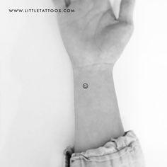 a person's hand with a small wrist tattoo on the left side of their arm