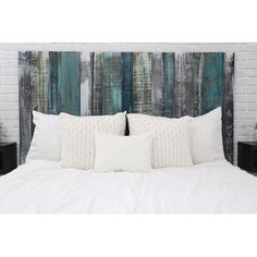 a bed with white pillows and wooden headboard