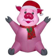 an inflatable pig wearing a santa hat and scarf