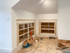 an empty room with unfinished shelves and tools on the floor