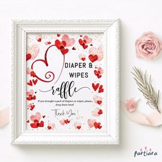 a white frame with red and pink hearts on it, next to some dried flowers