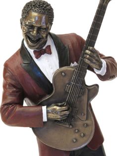 a statue of a man with a guitar in his hand and wearing a tuxedo