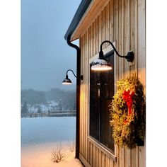 a light on the side of a building with a wreath hanging from it's side