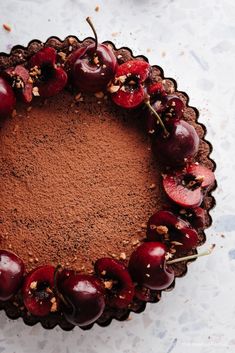 a chocolate cake topped with cherries and nuts