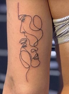 a woman's leg with a tattoo on it that has lines and shapes in the shape of two faces